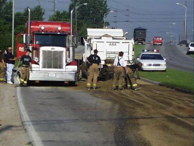 ER-0004
Photo Date: 7/31/2001
Photo Credit: Jason Ravenscroft
Description: First responders applying sand to fuel spilled from the saddle tanks of a semi tractor-trailer during an accident.

