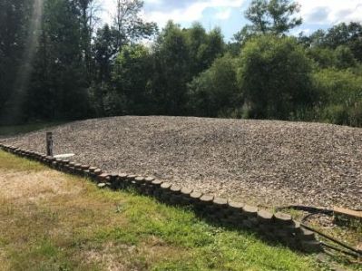 OWS-0032
Photo Date: August 1, 2019
Photo Credit: Brett Davis
Description: While doing a site investigation for a property down the road, I came across a mound that has ZERO vegetative cover. In fact, one could argue that it has an oversized aggregate bed! This mound is from the early 2000s and it has the dosing tank within the sand area of the mound, is on the edge of a wetland, and is built as a sloping site mound-but the slope is going the wrong way!

