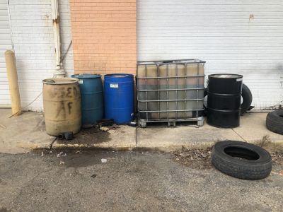 SHW-0017
Photo Date: 02/27/2019
Photo Credit: Kyle Fender
Description: Abandoned drums and intermediate bulk containers of vehicle fluids at a closed vacant auto shop. Some containers are spilling on the ground, some are missing caps leaving them open to infiltration of precipitation, and some are missing proper labeling on some containers. 
