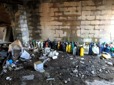 SHW-0023
Photo Date: 12/17/2018
Photo Credit: Kyle Fender
Description: Several gallons of motor oil and other vehicle fluid containers were found abandoned in a vacant space next to a business in a wellfield protection area. 

