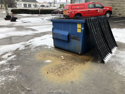 SHW-0024A
Photo Date: 02/11/2019
Photo Credit: Kyle Fender
Description: Containers of vehicle fluids were improperly disposed of in a dumpster and the leaking fluids mixed with the melting snow in the dumpster and leaked onto the pavement at a facility located within a wellfield protection area. 
